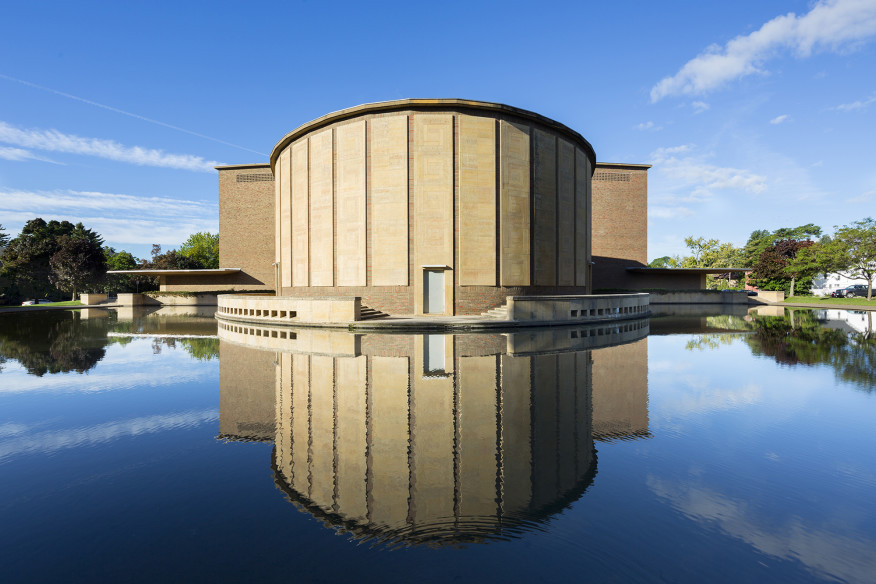 The chamber music hall as viewed from across the reflecting pool. <i><figcaption id=